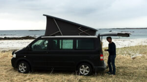 Lofoten VW Camper vacations in Lofoten Islands Lofoten VW Camper Californian camper van with the pop up roof open on a beach
